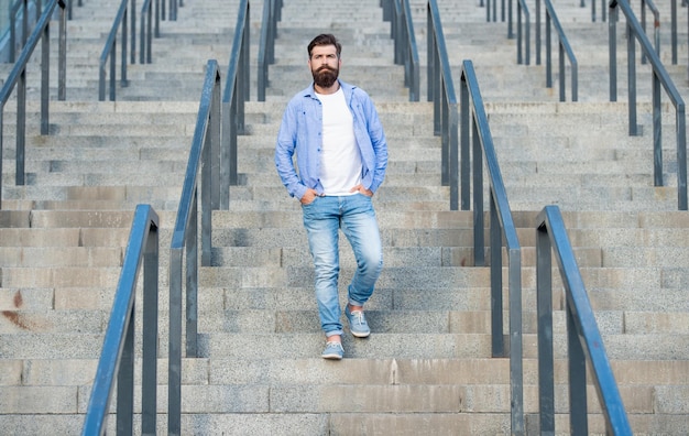 Bebaarde man loopt naar beneden volledige lengte van man met baard hipster man buiten trap af