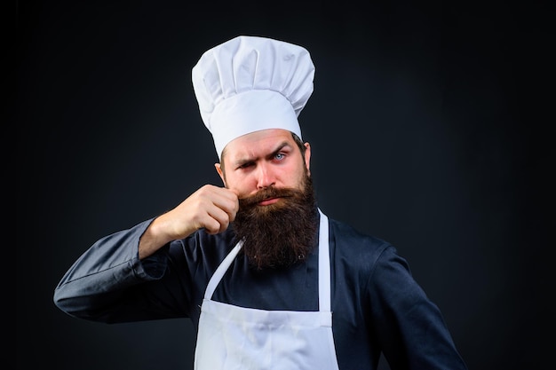 Bebaarde man mannelijke kok in chef-kok hoed bebaarde man chef-kok in uniform chef-kok of bakker man professional