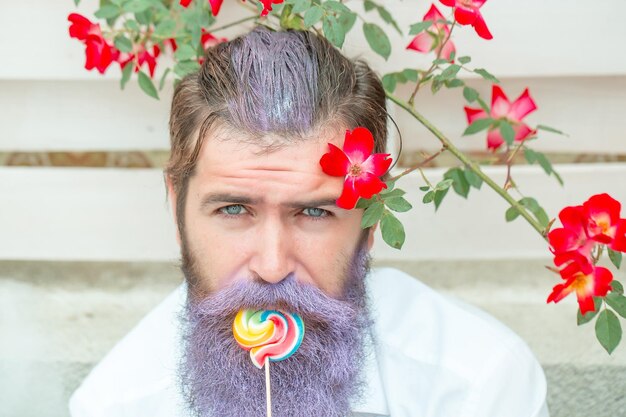 Foto bebaarde man met blauwe baard en lolly