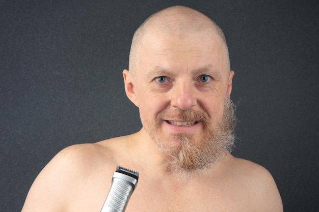 Foto bebaarde man met trimmer om de baard in de hand te verzorgen en een modieuze kapperszaak baardlengtecorrectie