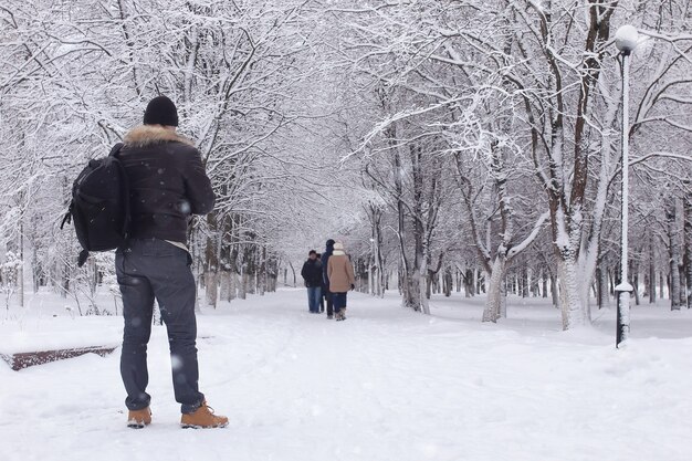 Bebaarde man wandelen in een winter park sneeuwseizoen