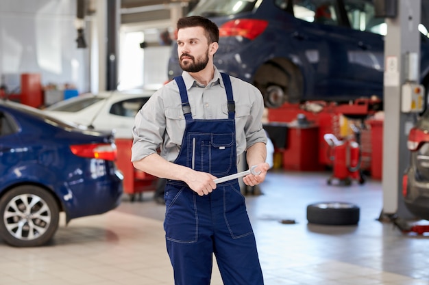 Bebaarde Mechanic Working in Car Service