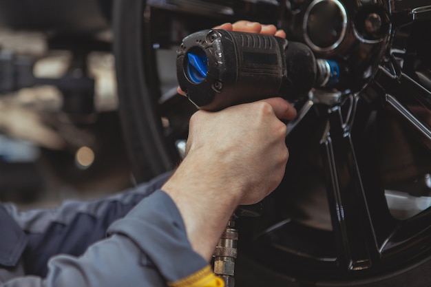 Bebaarde monteur werken bij auto tankstation