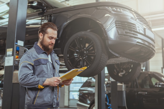 Bebaarde monteur werken bij auto tankstation