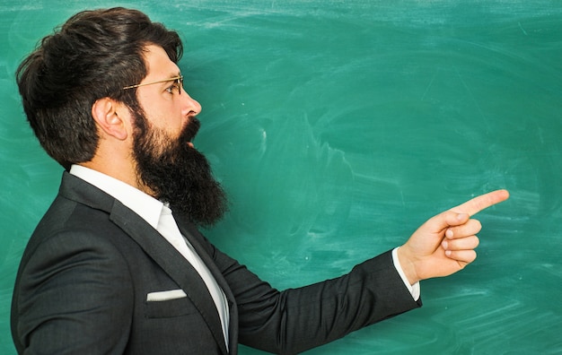 Foto bebaarde professor op school lesgeven op schoolbord