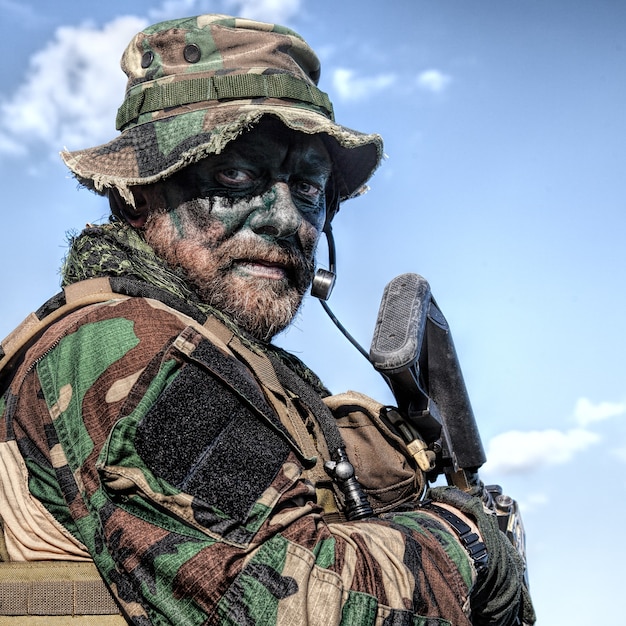 Bebaarde soldaat van speciale troepen op blauwe hemelachtergrond