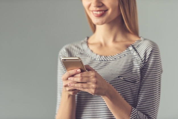 Bebouwd beeld van jonge vrouw die een smartphone gebruikt