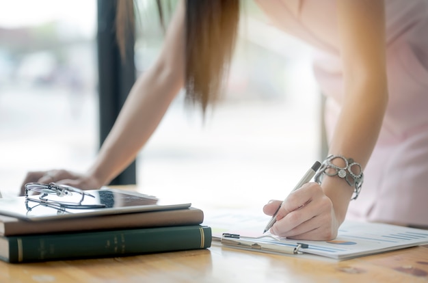 Bebouwd beeld van vrouwelijke de holdingspen van de handholding het schrijven nota over grafiek