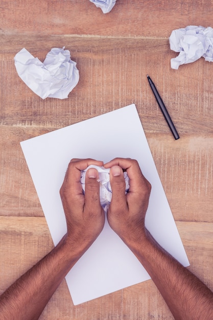 Foto bebouwd beeld van zakenman die document ballen maken bij bureau in bureau