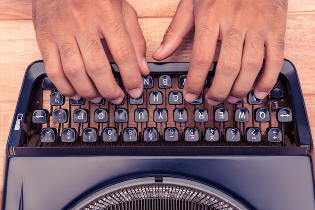 Bebouwd beeld van zakenman het typen op schrijfmachine bij bureau in bureau