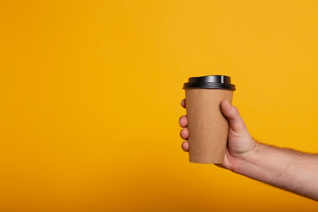 Bebouwde mening van de mens met koffie om op geel te gaan