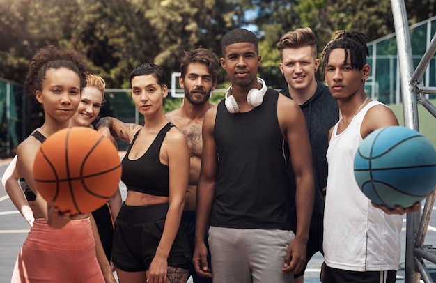 Photo becoming part of a team and a larger community portrait of a group of sporty young people standing together on a sports court