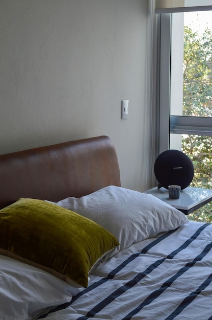 Bed base bedroom with mat on the floor clay pot in the background wooden credenza and mirror