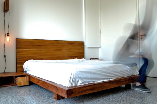 背景の木製クレデンツァと鏡の床土鍋にマット付きベッド ベース寝室