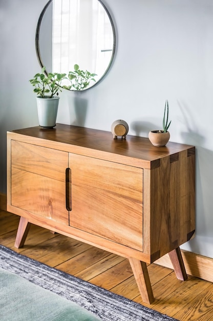 Bed base bedroom with mat on the floor clay pot in the background wooden credenza and mirror