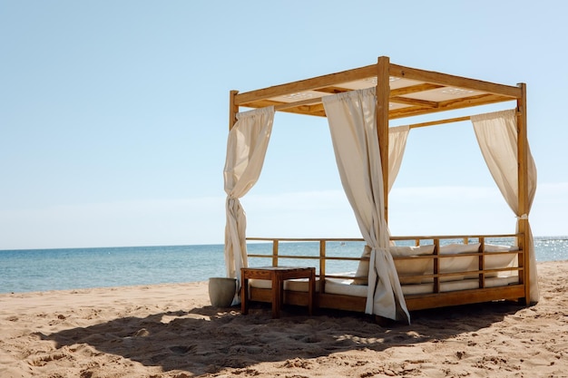 A bed on the beach with a canopy over it