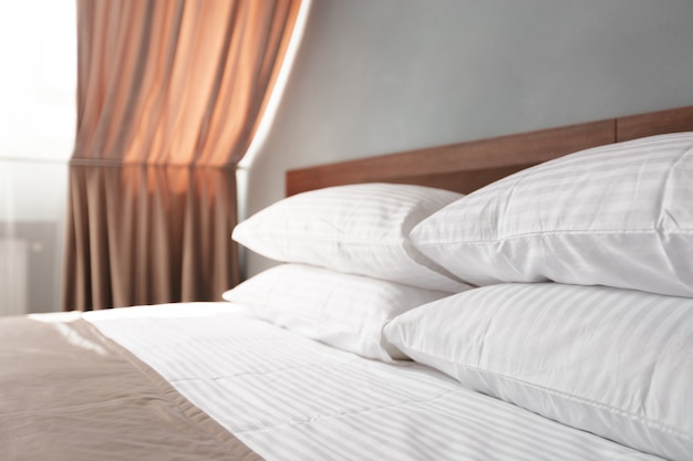 Bed maid-up met schone witte kussens en lakens in schoonheidssalon.