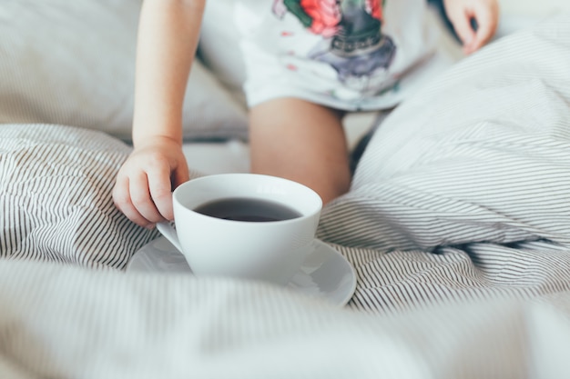 Bed maid-up with clean pillows and bed sheets in room. Morning breakfast with tea. Kid hol