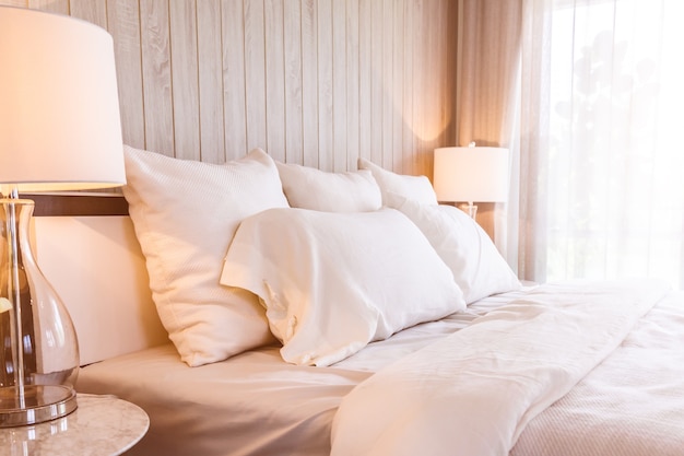 Bed maid-up with clean white pillows and bed sheets in beauty room.