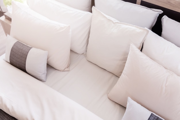 Bed maid-up with clean white pillows and bed sheets in beauty room. 