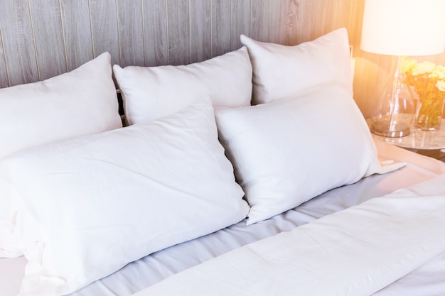 Bed maid-up with clean white pillows and bed sheets in beauty room. 