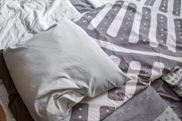 A bed maid up with a simple abstract pillow design on top