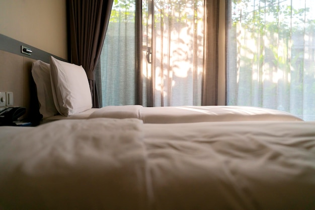 Bed maidup with clean white pillows and bed sheets in beauty room Closeup Lens flair in sunlightCloseup of new bed comforter with decorative pillows headboard in bedroom in staging model home