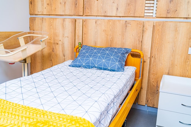 Bed for mother and newborn child cradle in modern hospital Uptodate interior in clinic Light colors in clinic room Closeup