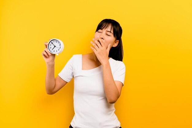 Bed time rest time sleepy sleep on time the importance of sleep and relaxation Young female hand holding a watch and showing sleepiness