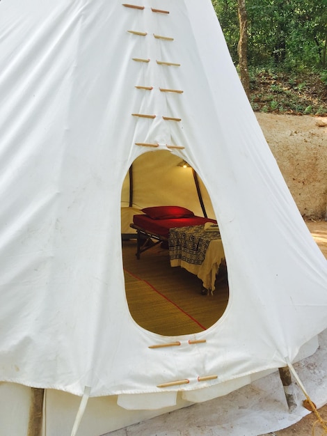 Photo bed in white tent seen through entrance hole