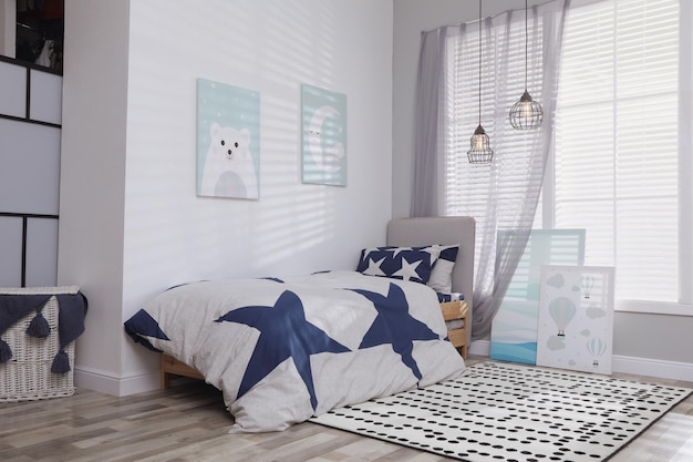 Photo bed with stylish linens in children's room interior design