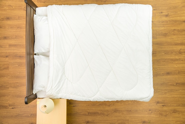 The bed with a white linens. View from above