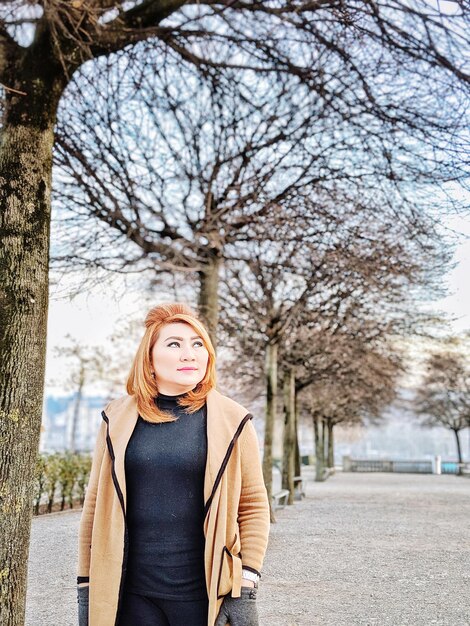 Foto bedenkende vrouw die in het park staat