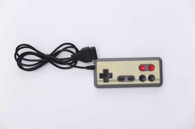 Bedrade retro gamepad en joystick met gewikkelde kabel op witte achtergrond. Videospelletjes, gamen. Bovenaanzicht