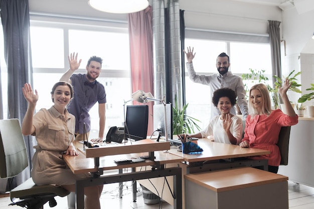 Foto bedrijf, opstarten en kantoorconcept - gelukkig creatief team dat de handen zwaait in kantoor