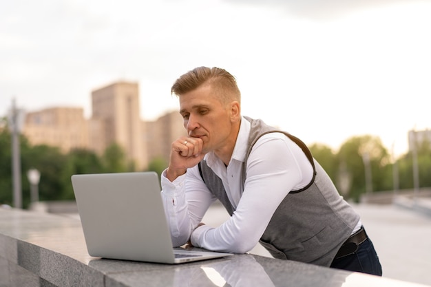 Bedrijf. Zakenman Met Behulp Van Laptop Buiten. Ernstige peinzende blanke man bedrijfspersoon Computer buiten moderne technologie Concept jongvolwassen manager Crisis denken probleem idee