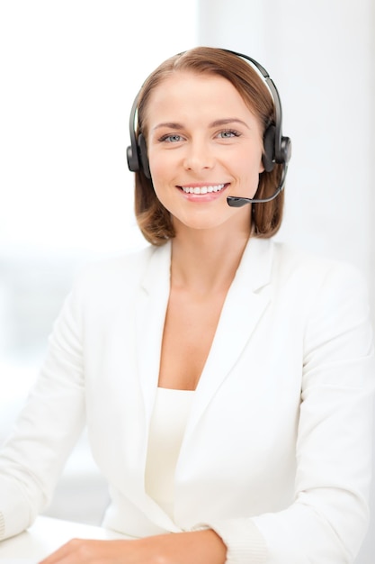 bedrijfs-, communicatie- en callcenterconcept - glimlachende vrouwelijke hulplijnoperator met koptelefoon in callcenter