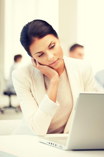 bedrijfs- en communicatieconcept - zakenvrouw met laptop op het werk