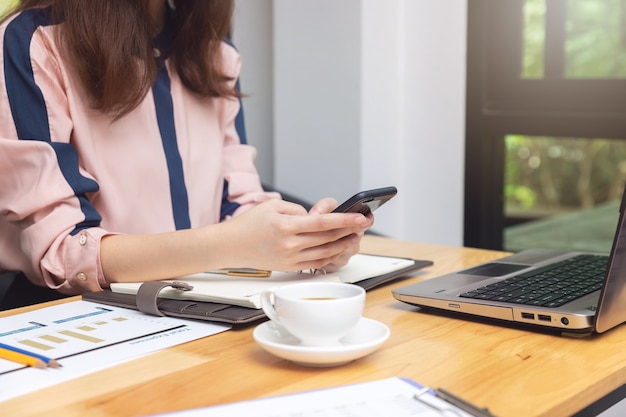 Bedrijfs en financiënconcept, Onderneemster die de Grafiek van de verkoopanalyse in koffiewinkel bespreken