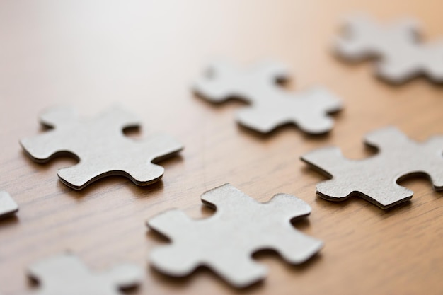 bedrijfs- en verbindingsconcept - close-up van puzzelstukjes op houten oppervlak