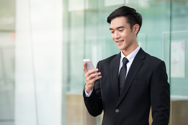 Bedrijfs mens die mobiele telefoon voor het werk met behulp van of online winkelt.