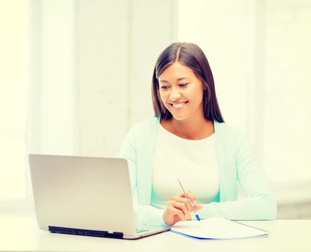 bedrijfs-, onderwijs- en technologieconcept - Aziatische zakenvrouw of student met laptop en documenten op kantoor
