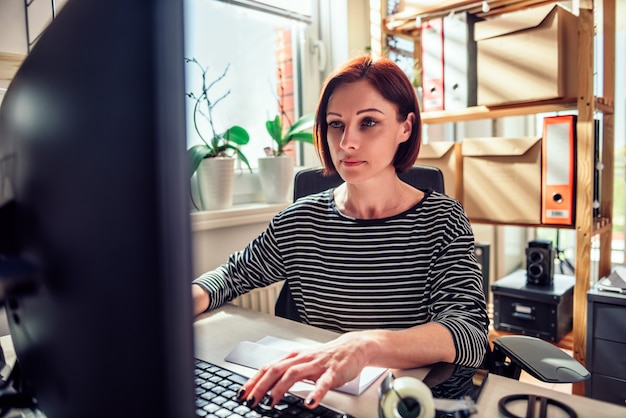 Bedrijfs vrouw die aan computer op het kantoor werkt