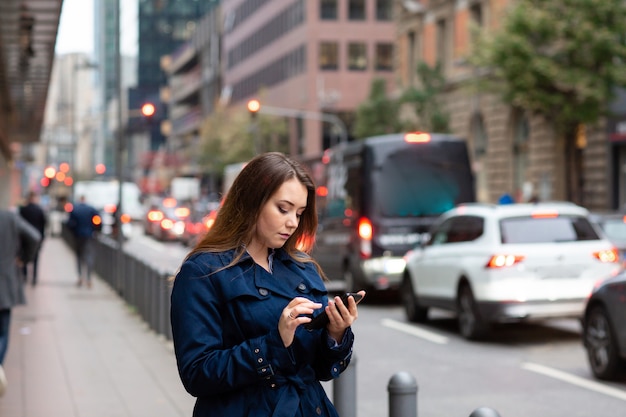 Bedrijfs vrouw die een plaats in de telefoon, voor een commerciële vergadering kijkt. Halve lengte foto.