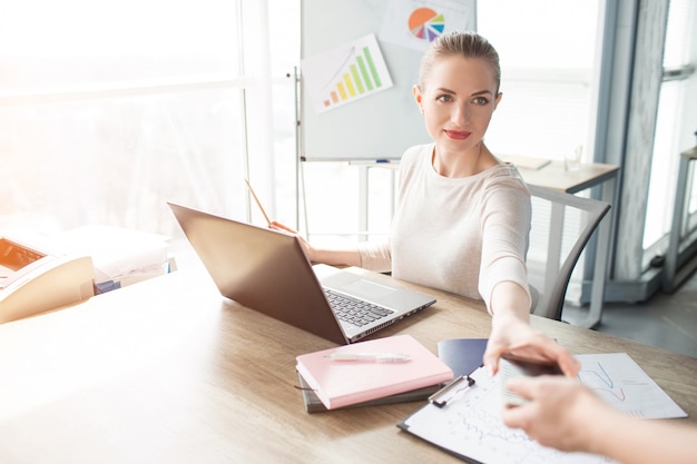 Bedrijfs vrouw die haar telefoon krijgt van haar helper