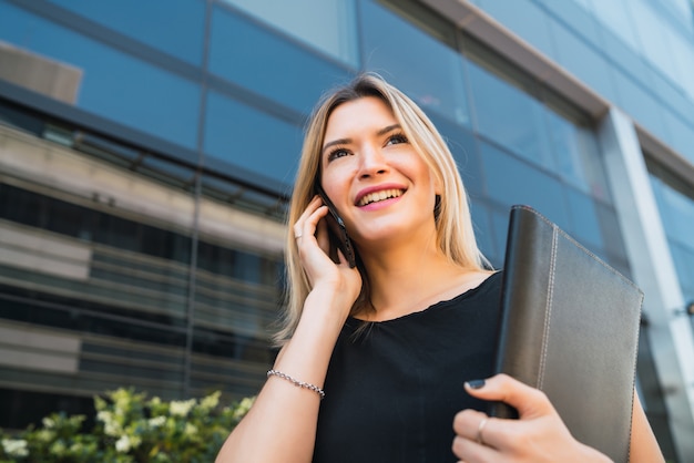 Bedrijfs vrouw die op de telefoon spreekt.