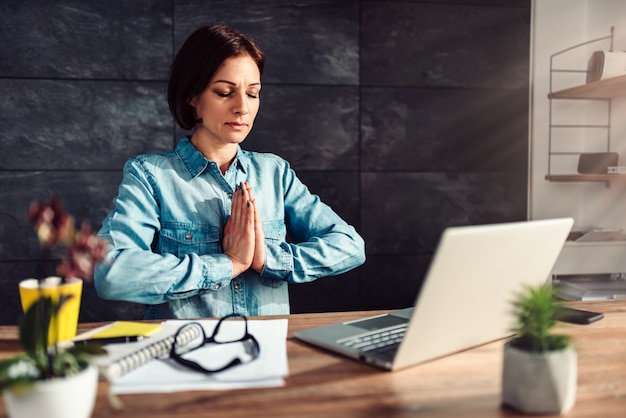 Bedrijfs vrouw die op het werk mediteert