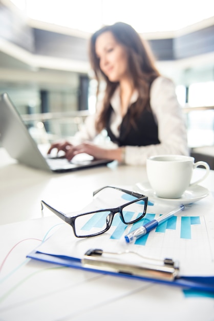 Bedrijfs vrouw die voor laptop in een modern bureau werkt.