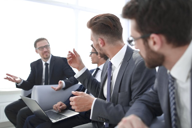 Bedrijfscollega's die in het bedrijfsconcept van de bureauwachtkamer zitten