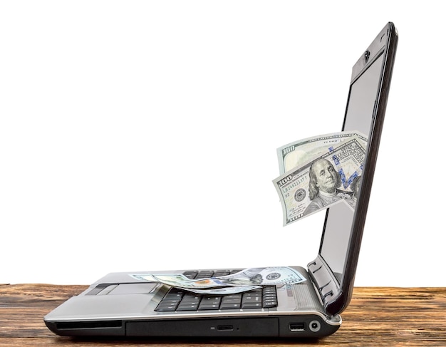 Bedrijfsconcept Geld dat van laptopscherm naar het toetsenbord valt Online geld verdienen Geïsoleerd op wit